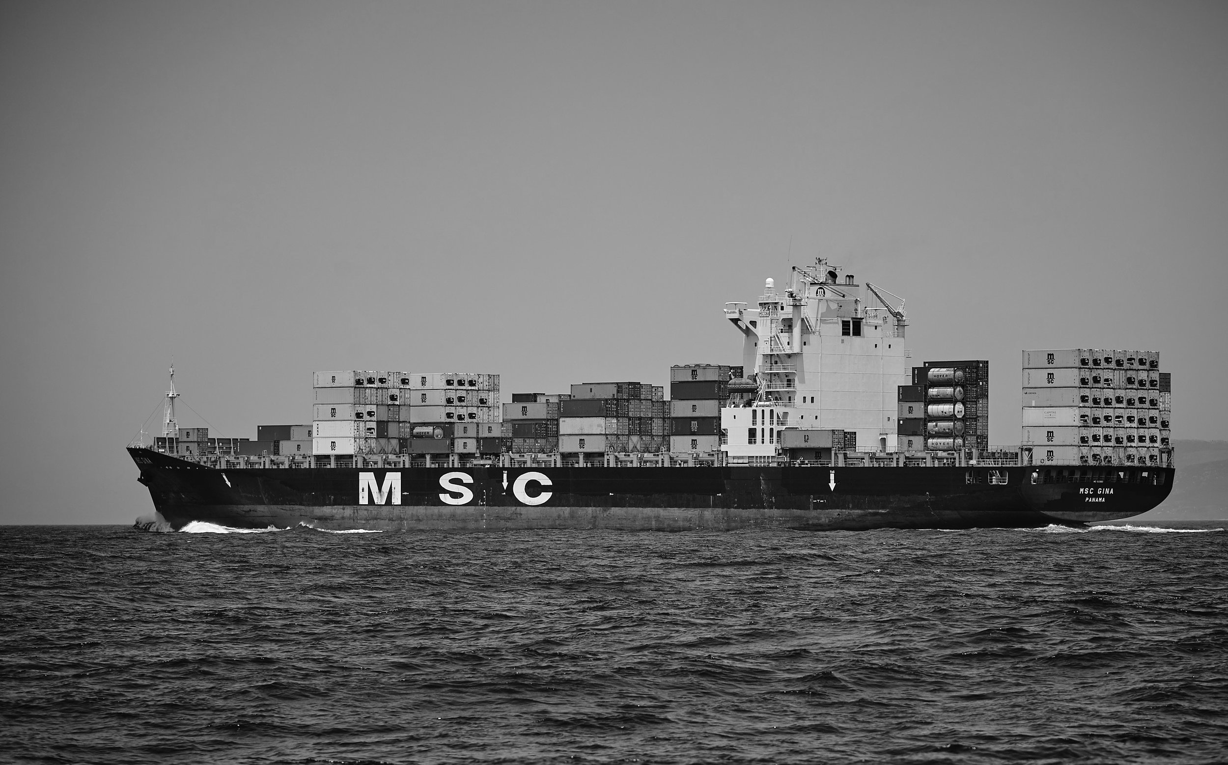A container ship on the ocean, seen from the side