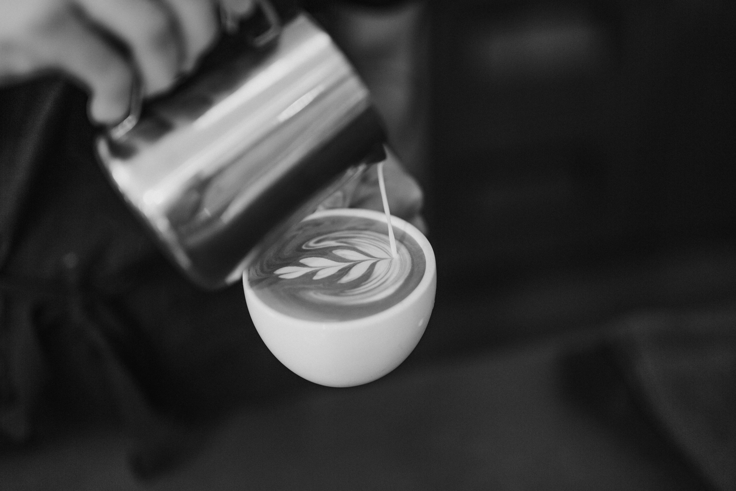 A barista pours latte art