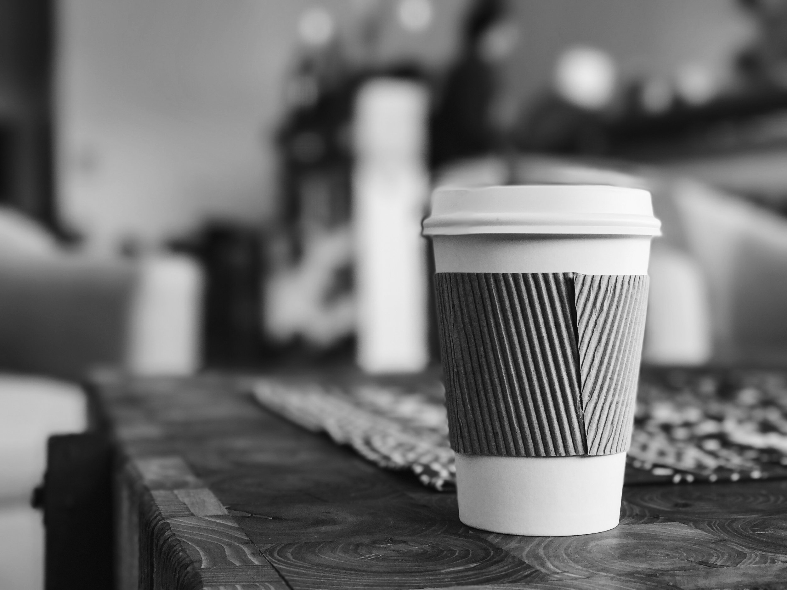 A disposable coffee cup sits on a table