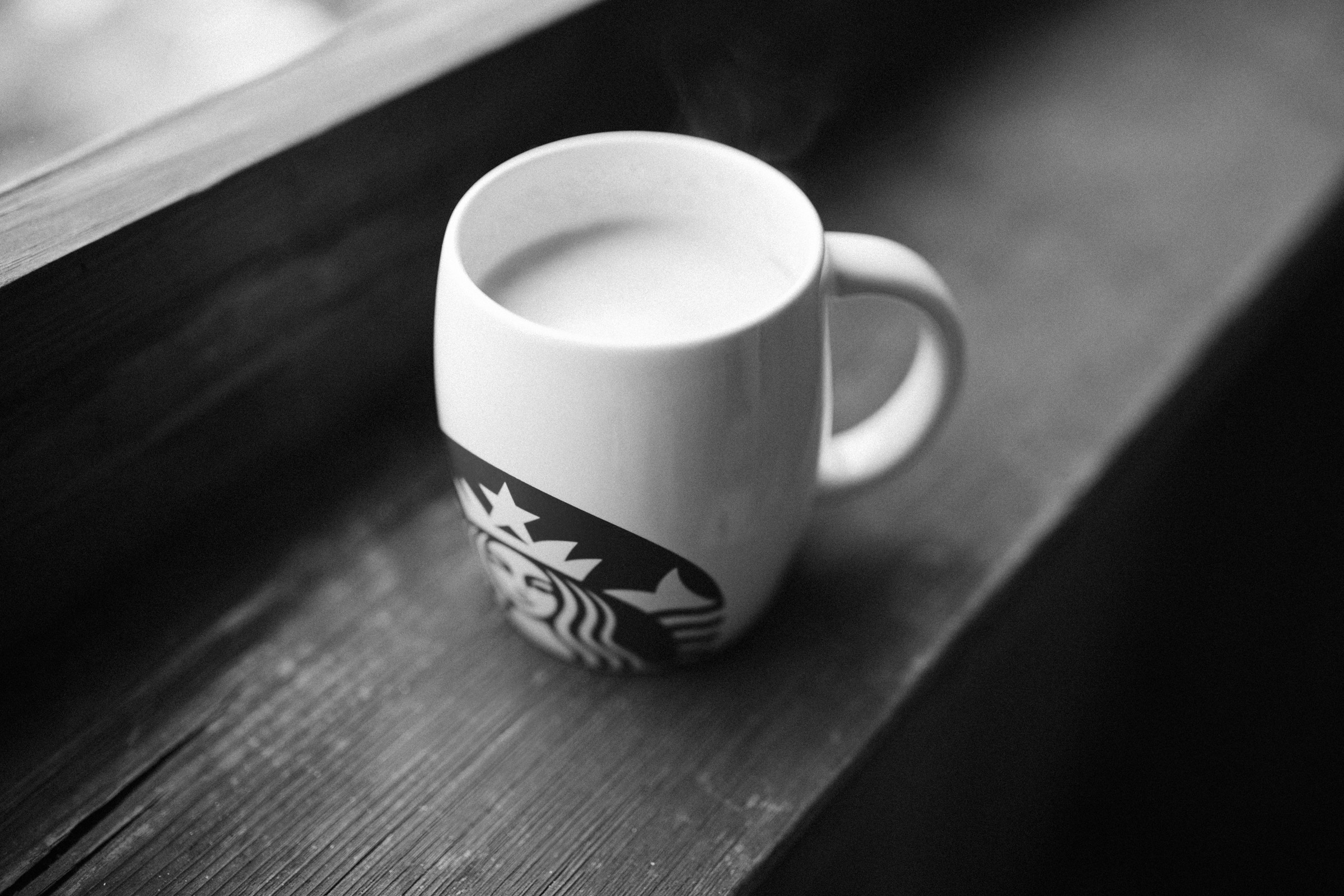 A Starbucks mug sits on a windowsill