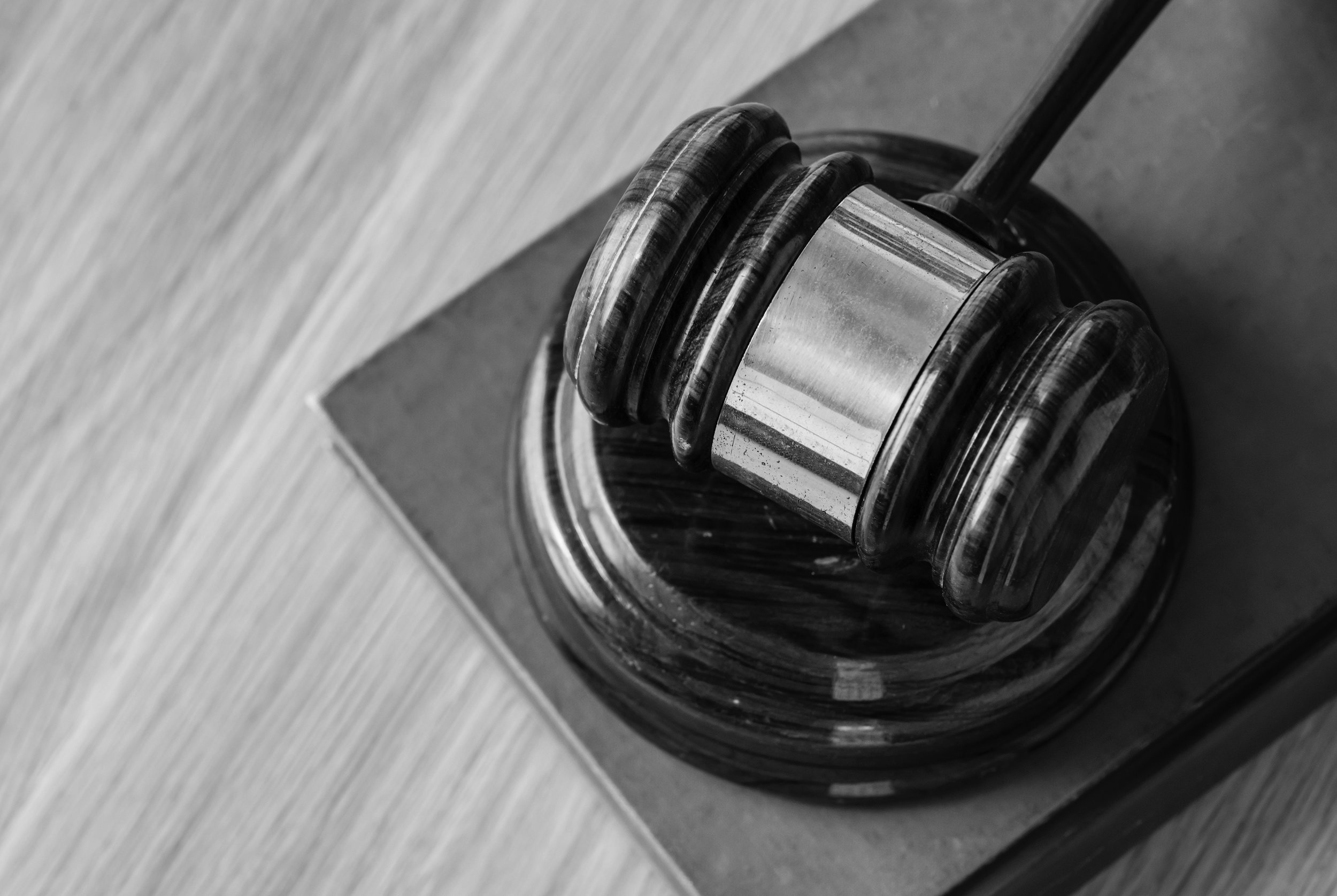 A wooden gavel rests on a sound block.