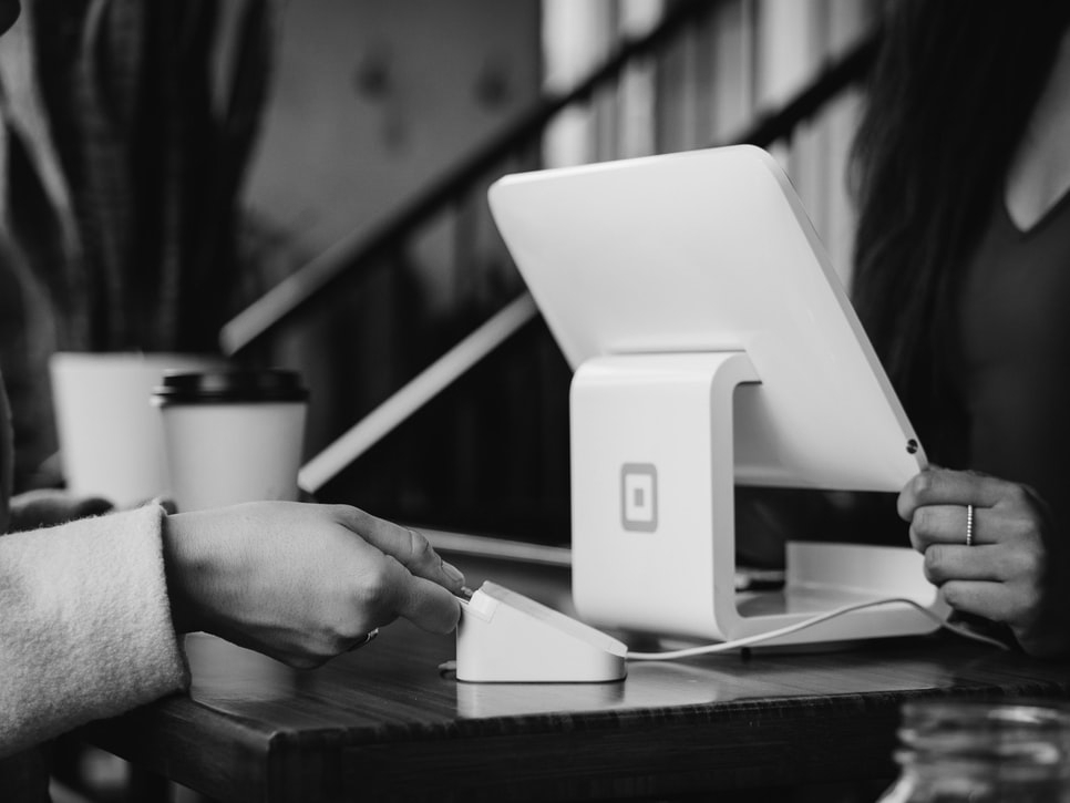 A person pays with a credit card using Square’s white point of sale system.