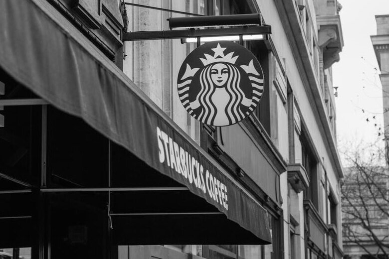 A Starbucks logo sign hangs from a building