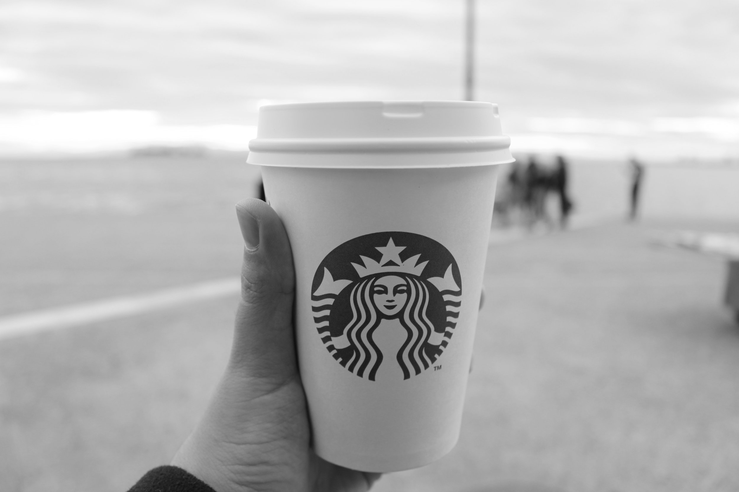 A Starbucks coffee cup being held in front of the camera.