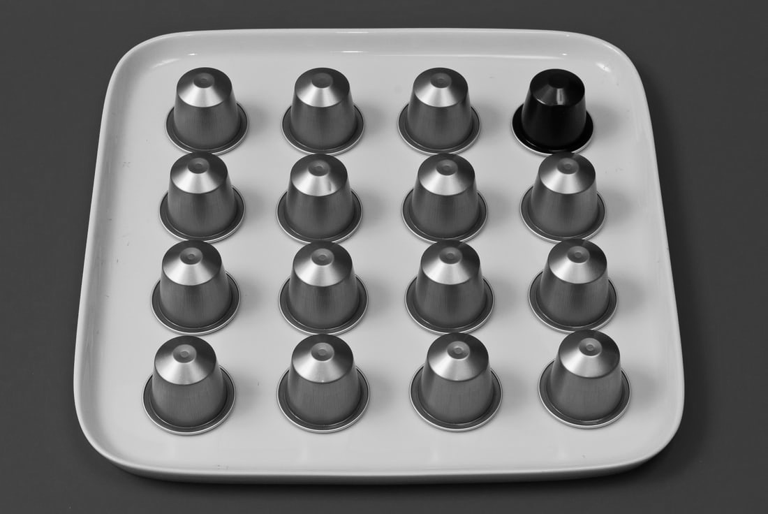 Coffee capsules lined up on a tray.