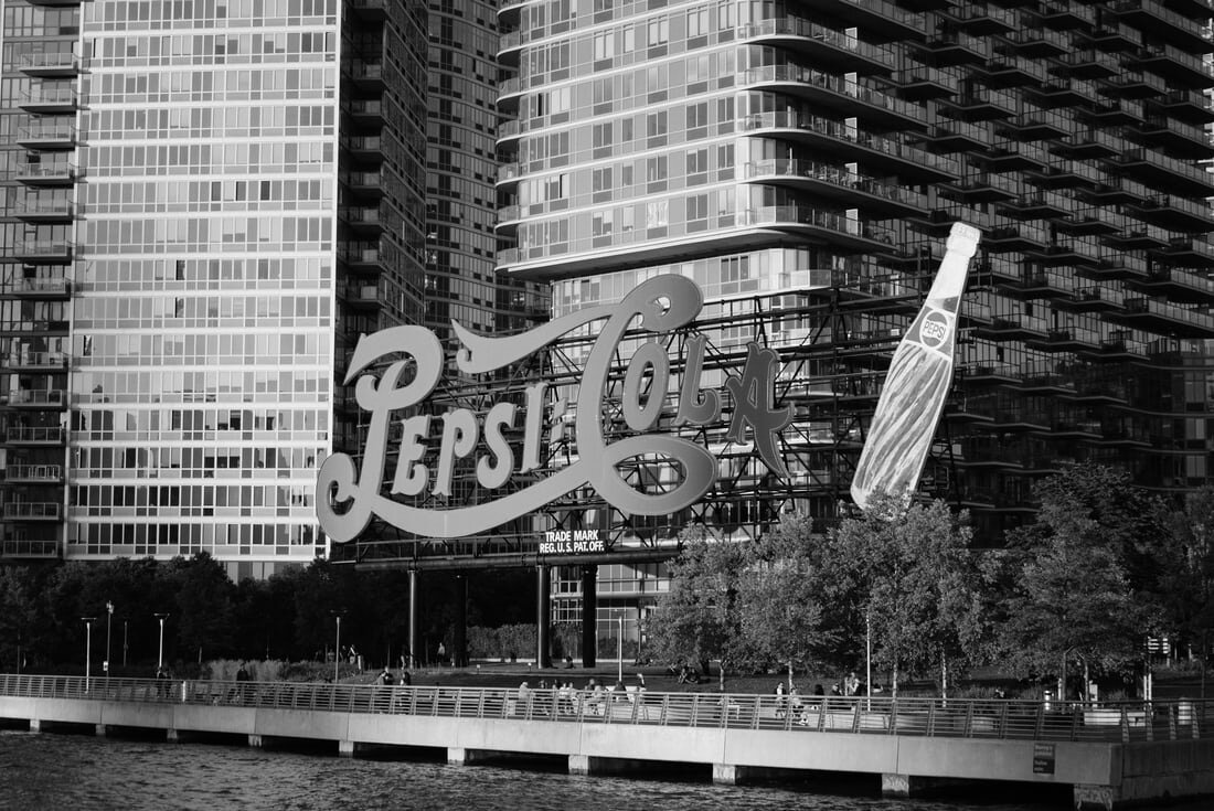 A Pepsi-Cola sign in front of an apartment block