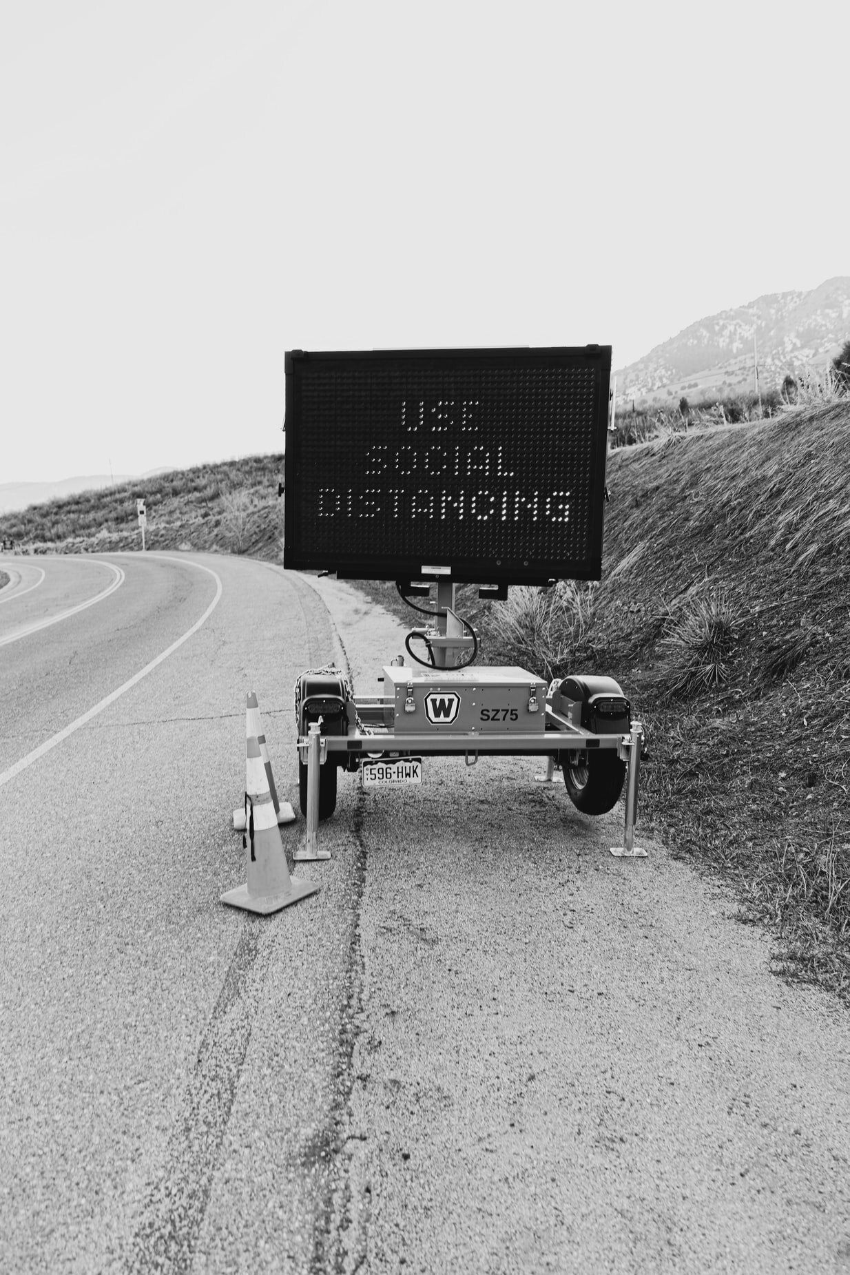 A temporary construction road sign that says USE SOCIAL DISTANCING.&nbsp;Via Unsplash.