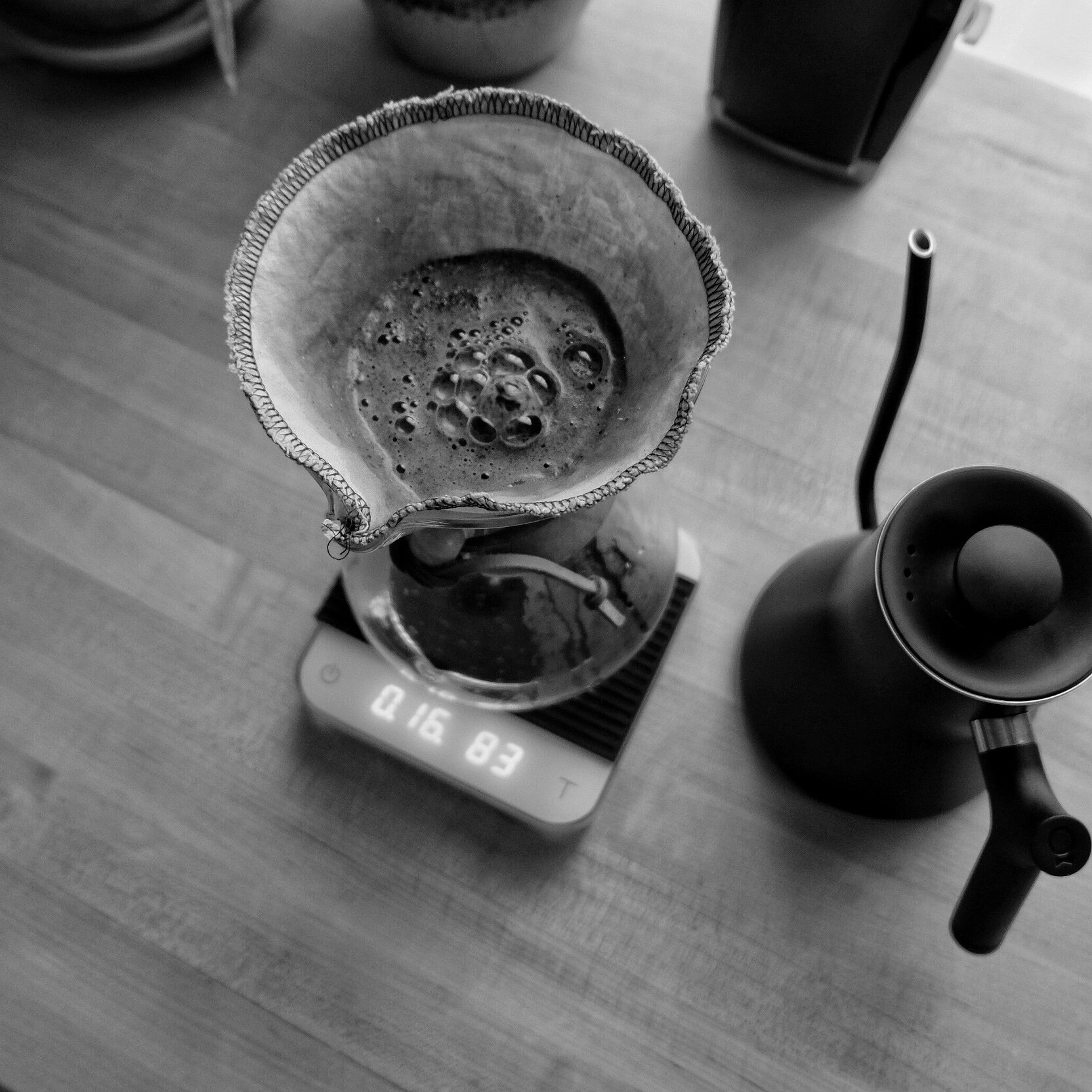 A Chemex and kettle seen from above, with coffee blooming in the Chemex