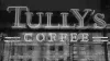 A neon sign for Tully's Coffee seen through a window