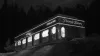 A retro diner on a hill at night, with light shining from its windows and "Penny's Dinner, open 24 hrs" in neon