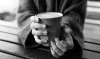 Close up of two hands holding a latte
