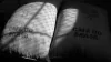 Two sacks of green coffee, one in shadow, with CAFÉ DO BRASIL written on them