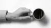 Close up of a hand holding a cup of coffee on a table, seen from above. The coffee cup has Matrix raining code inside.