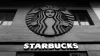 Looking up at a Starbucks store sign with the name in white letters and an ominous black metal logo
