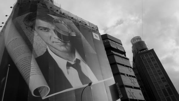 A giant advertisement covering a highrise building showing George Clooney in an ad for Nespresso